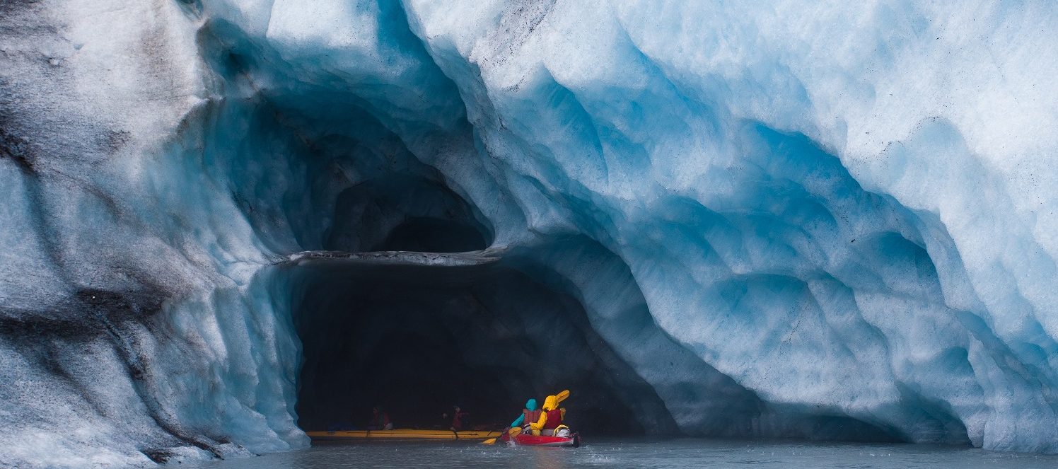 Kayaking into a blue ice cave in Alaska.