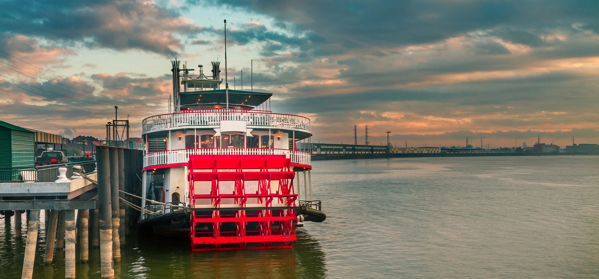 Steamboat docked on the Mississippi River at sunset.