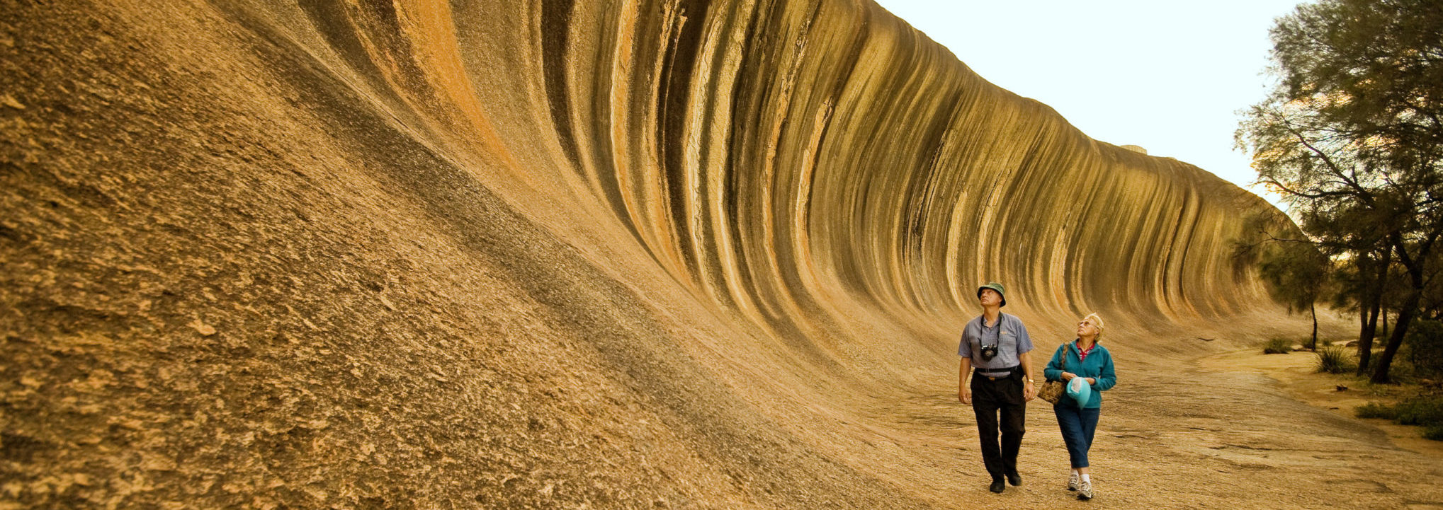 Couple walking beneath Wave Rock