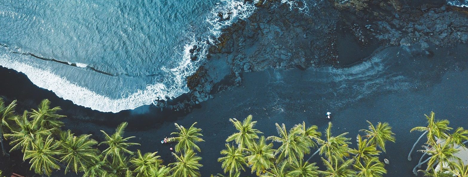 Waves crashing on black sand, Hawaii.