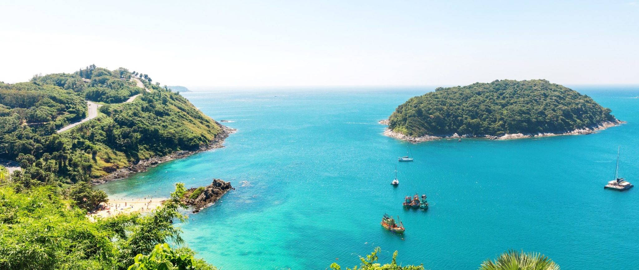 Aerial shot of blue water and green foliage on an island in Thailand.