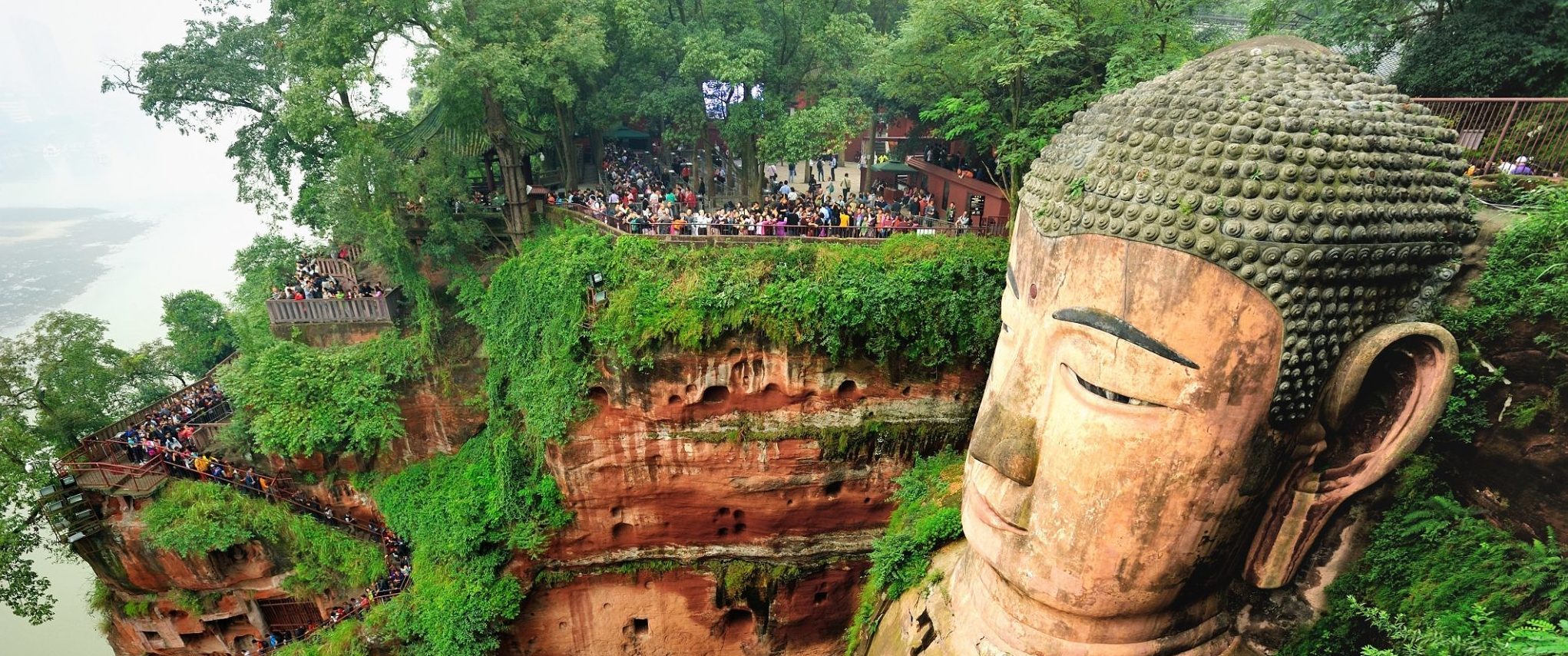 Tourists looking at the Leshan giant Buddha, China.