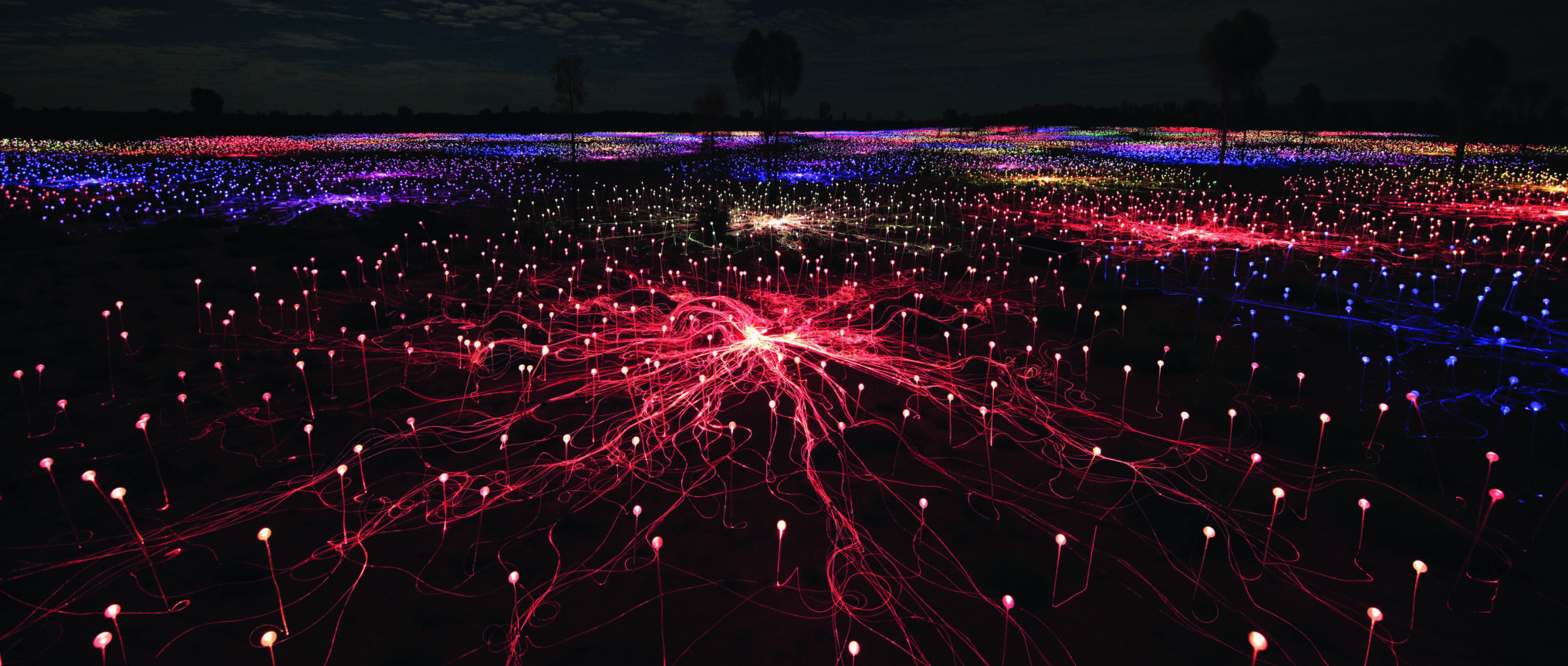 An array of red, blue and yellow lights on the ground during the evening.