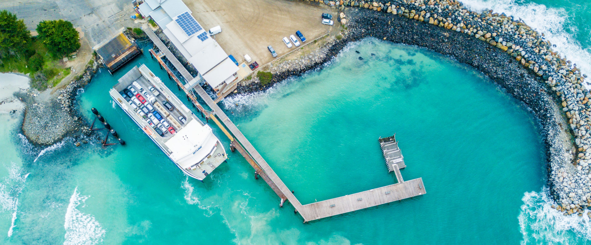 Blue crystal water and a ferry docked.