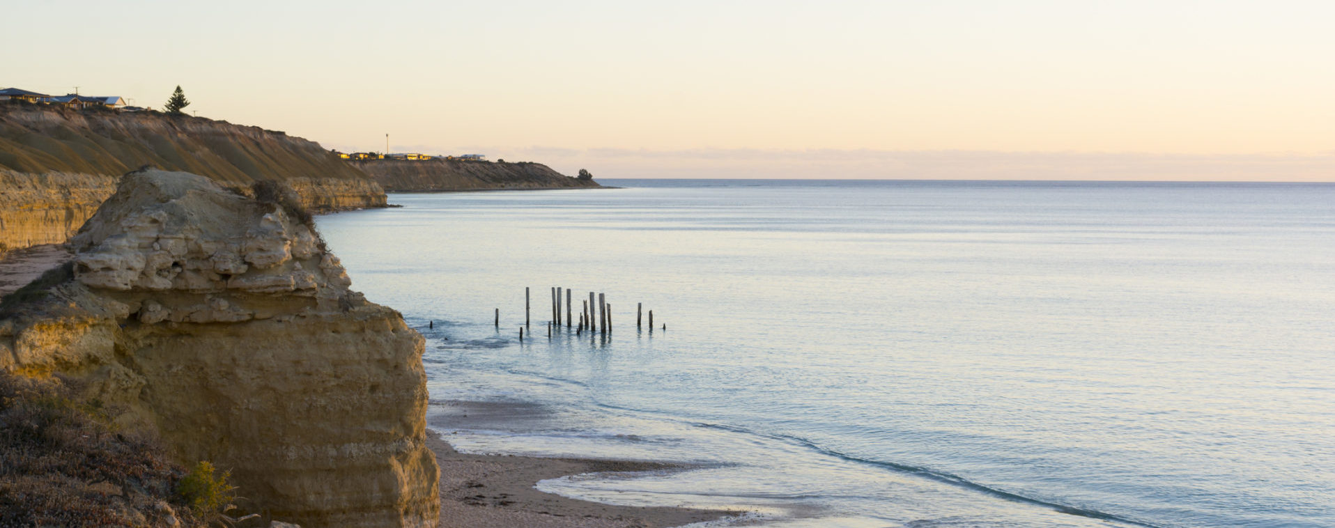 Looking down at the jetty ruins at Port Willunga, South Australia, during the golden hour, nearing sunset and at high tide.