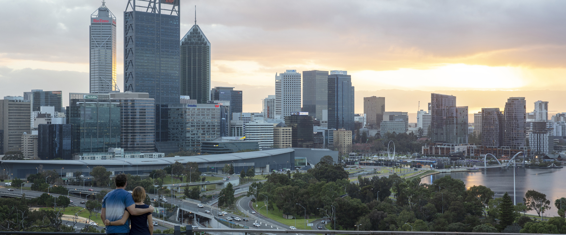 Two people sitting looking at the Perth skyline from Kings Park.